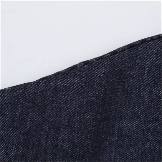 Close-up of elegant denim fabric texture showcasing stitching detail for Skjortklänning.