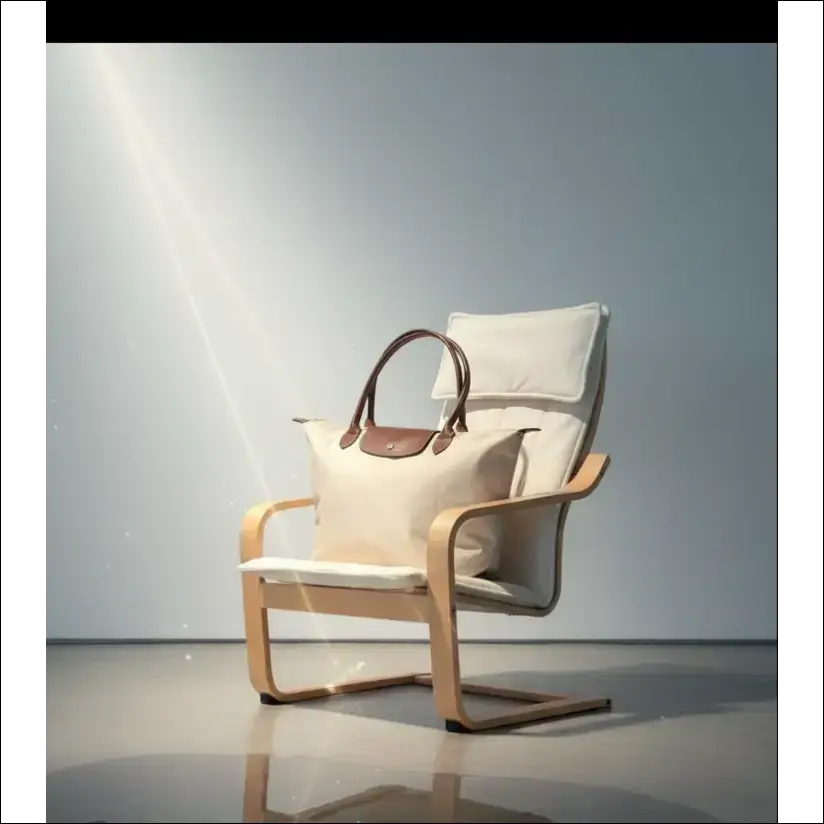 Longchamp Le Pliage L på en stol med en elegant och minimalistisk design i krämvit färg.